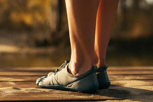 Barefoot shoes with thin soles and wide toe box on grass under soft sunlight.
