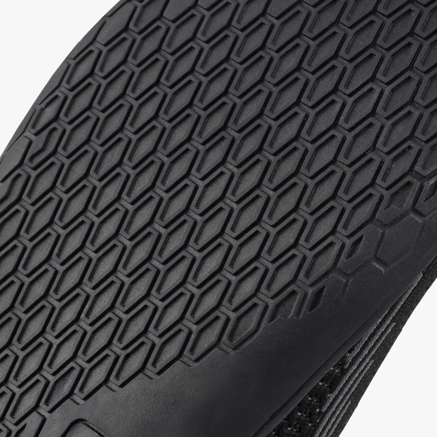 Black barefoot training shoe with hexagonal tread pattern, wide toe box design